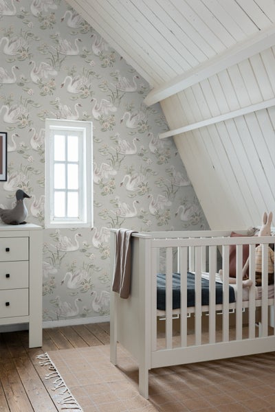 Helles Schlafzimmer mit Schwanentapete, Bettwäsche und Wandleuchte.