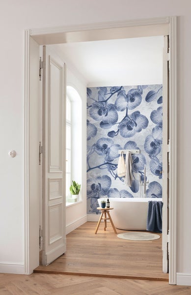 Badezimmer mit Orchideen Tapete, Badewanne und Holzboden durch offene Tür