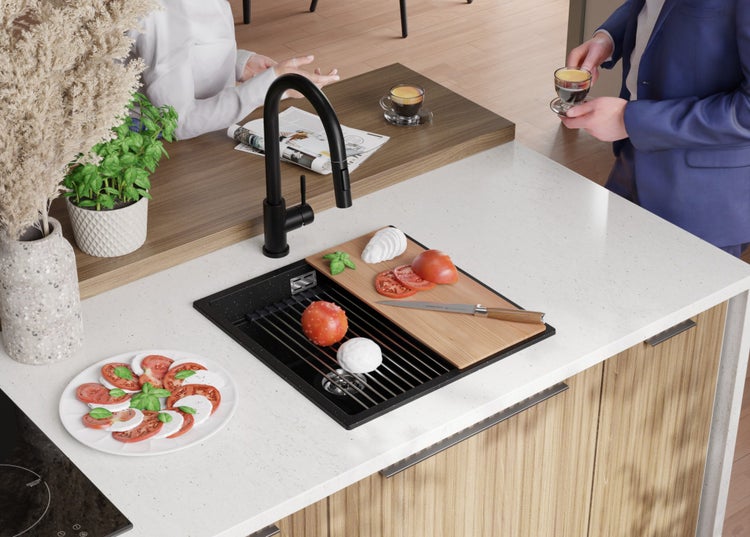 Küchenszene mit Spüle, Armatur, Schneidebrett, Tomaten, Mozzarella und Geschirr