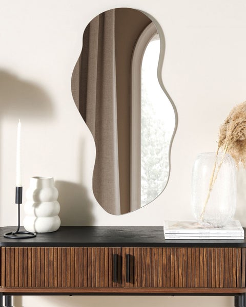 Dekoratives Interieur mit Konsolentisch, Spiegel, Kerzenständer und Vasen