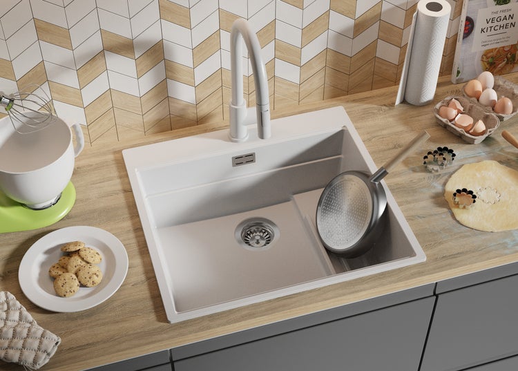 Küchenszene mit Spüle, Armatur, Kochutensilien und Backzutaten auf einer Arbeitsplatte