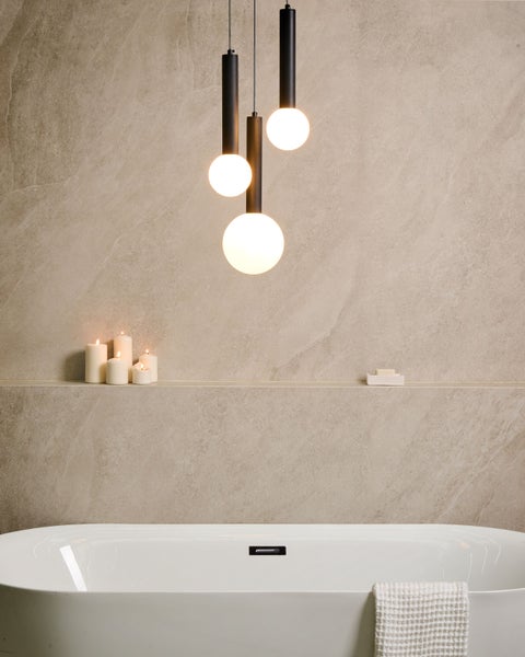 Badezimmer mit Badewanne, Wandfliesen, Kerzen und Hängelampen
