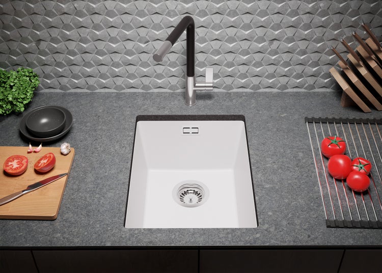 Küchenspüle mit Armatur, Schneidebrett und Abtropfgestell auf einer Arbeitsplatte