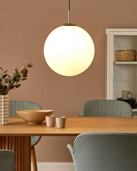 Esszimmer mit Holztisch, Stühlen, Hängeleuchte und Dekoration