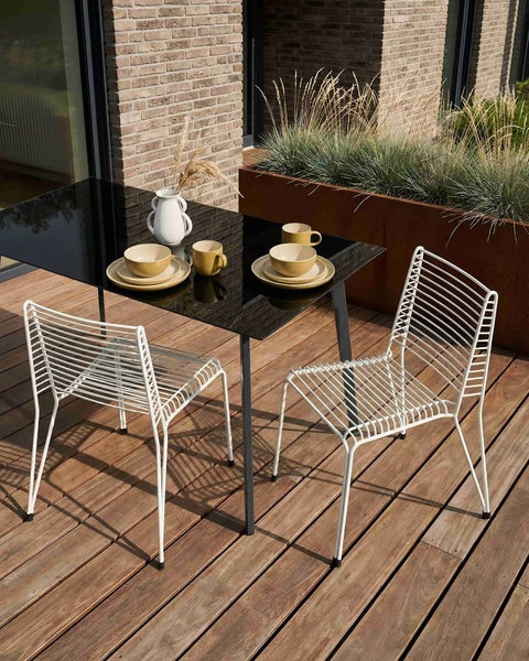 Zwei weiße Drahtstühle für den Außenbereich
