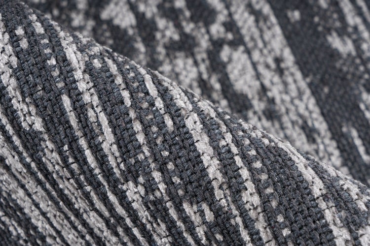 Nahaufnahme eines gewebten Teppichs mit gestreiftem Muster in Anthrazit und Grau, strukturierte Oberfläche.
