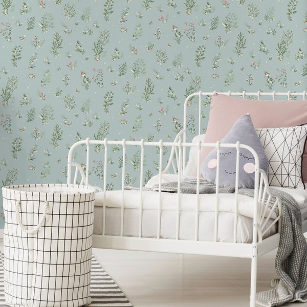Tapete mit botanischem Muster in einem Kinderzimmer mit weißem Schreibtisch, Lampe und Spielzeug.