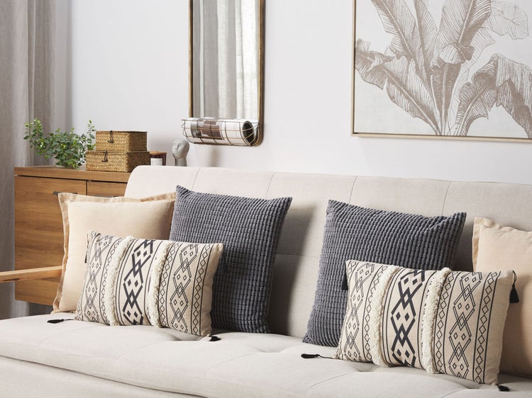 Zwei dekorative Kissen mit geometrischen Mustern und Quasten