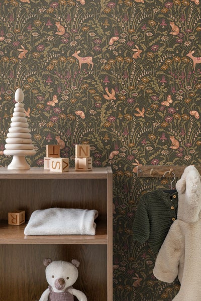 Vliestapete mit Waldtiermotiv wie Rehen, Füchsen und Hasen sowie Blumenmuster in einem Kinderzimmer mit Holzregal und Spielzeug.