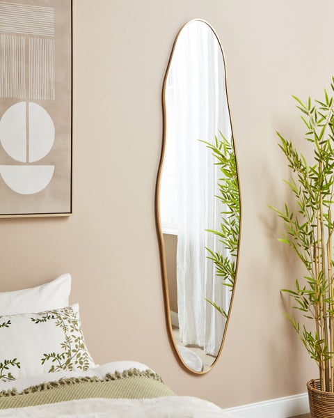 Langer Spiegel mit unregelmäßigem Rand und goldfarbenem Rahmen in einem Schlafzimmer