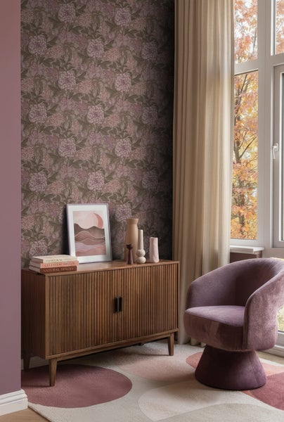 Modernes Wohnzimmer mit floraler Vliestapete, hölzernem Sideboard und einem Sessel aus Samt.