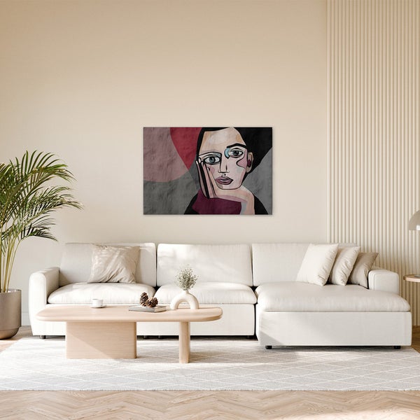 Wohnzimmer mit Sofa, Couchtisch und einem abstrakten Porträt an der Wand.