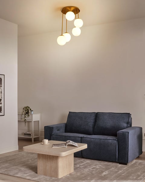 Wohnzimmer mit Sofa, Couchtisch, Stehlampe und Dekorationen für eine gemütliche Atmosphäre.