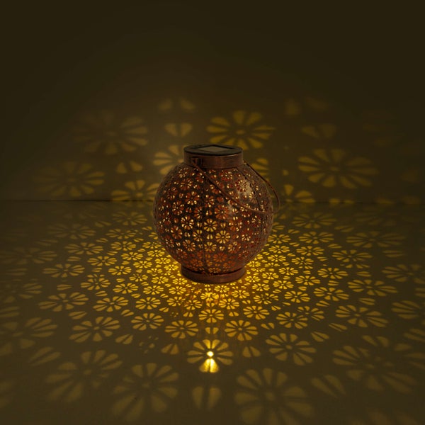 Dekorative Solarleuchte mit Blumenmuster auf einem Holztisch