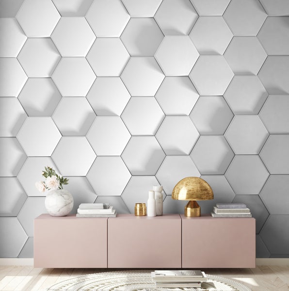 Moderne Wandgestaltung mit 3D-Wandpaneelen in Wabenoptik hinter einem rosafarbenen Sideboard mit Dekorationsgegenständen.