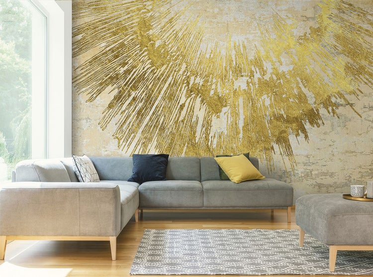 Wohnzimmer mit einer Wandtapete mit goldenem Muster, einer grauen Couch und einem gemusterten Teppich.