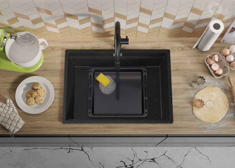 Küchenspüle aus Granit mit Armatur und Küchenutensilien auf einer Küchenarbeitsplatte