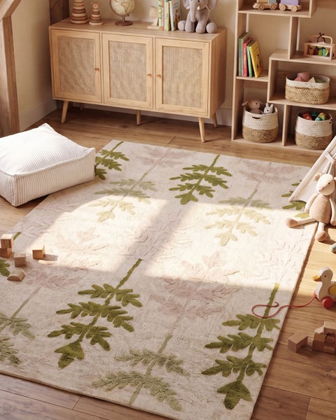 Kinderspielteppich mit Blattmuster in einem gemütlichen Kinderzimmer mit Holzmöbeln, Spielzeug und Körben auf einem Holzboden.
