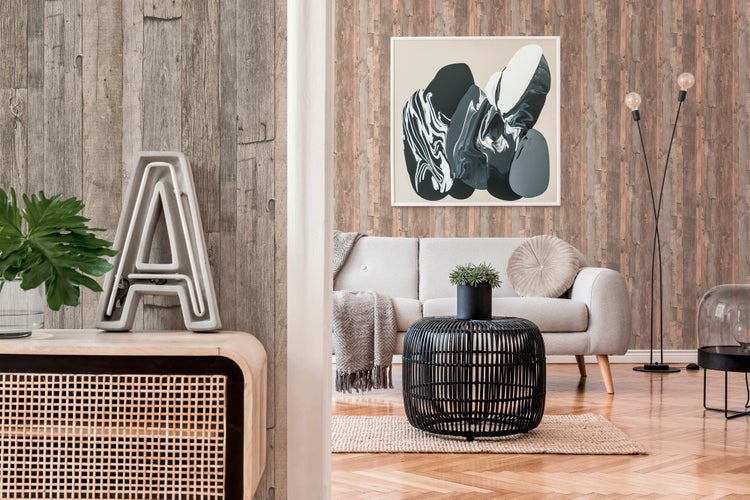 Wohnraum mit Holzpaneel-Tapete, Sofa, Dekokissen, Decke, Beistelltisch und London-Bild