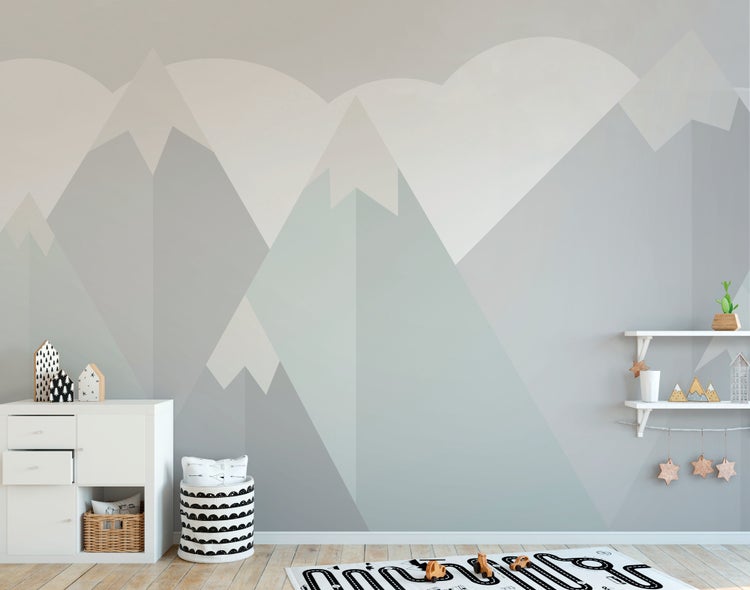 Fototapete mit geometrischem Bergmotiv in einem hellen Kinderzimmer mit weißen Möbeln und Holzfußboden.