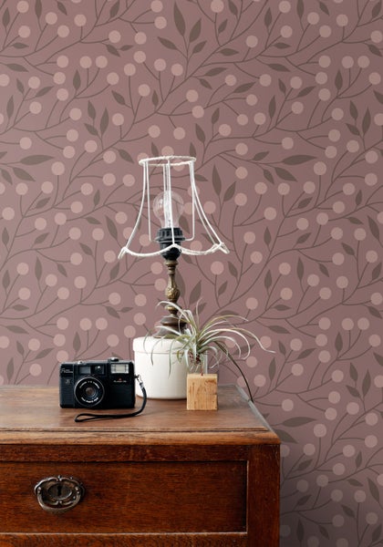 Zimmeransicht mit floral gemusterter Tapete, Kleiderschrank, Kinderkleidung und Accessoires.