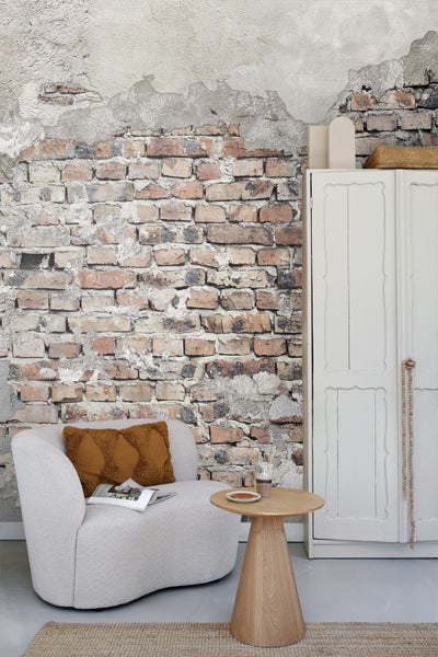 Wohnzimmer mit gemusterter Ziegelwand, Sessel und Beistelltisch
