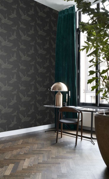 Raumansicht mit gemusterter Tapete, Vorhang, Schreibtisch, Stuhl und Zimmerpflanze