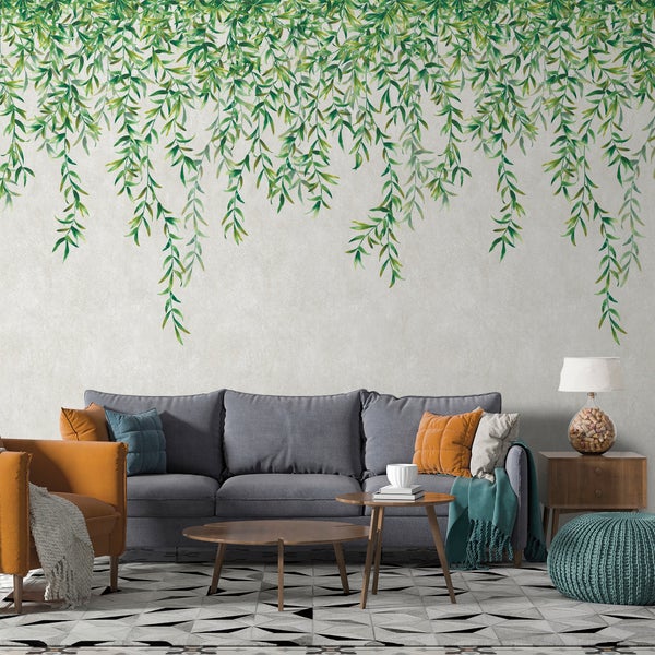 Wohnzimmer mit Sofa, Sessel, Tisch und Wanddekoration mit Blattmotiven