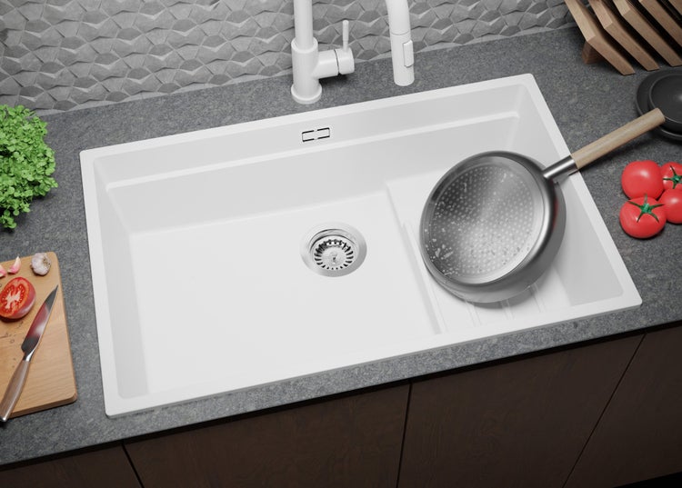 Spüle aus Quarzkomposit mit Abtropffläche, Armatur und Küchenutensilien auf einer Arbeitsplatte