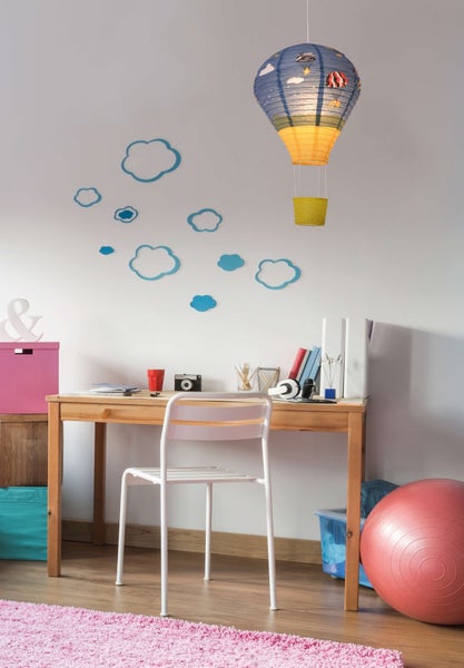 Helles Kinderzimmer mit Schreibtisch, Stuhl, Heißluftballon-Lampe und Dekorationen.