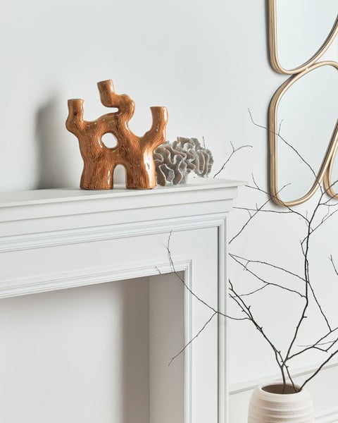 Dekoratives Keramikobjekt in abstraktem Design auf einem Kaminsims