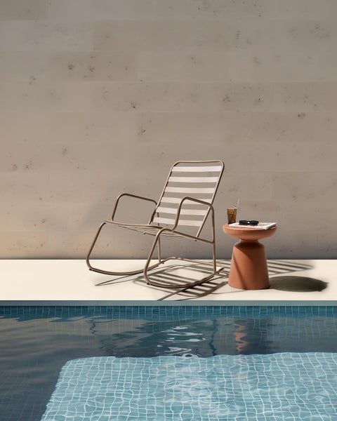 Szene am Pool mit Schaukelstuhl und Beistelltisch