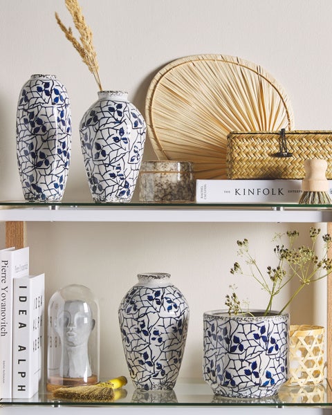 Dekoratives Regal mit Vasen, Büchern und Ziergegenständen für den Wohnbereich.