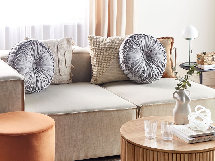 Wohnzimmer-Szene mit Sofa, Kissen und Tischdekoration