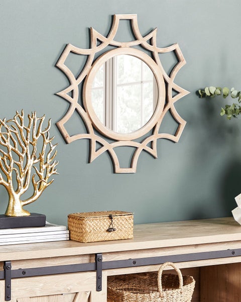 Dekorative Szene mit Spiegel, Deko-Baum, Schachtel und Kommode.