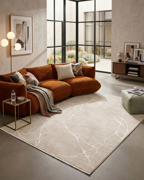 Modernes Wohnzimmer mit einem Sofa aus Cord, einem Teppich mit abstraktem Muster, einem Glastisch und einer Stehleuchte.