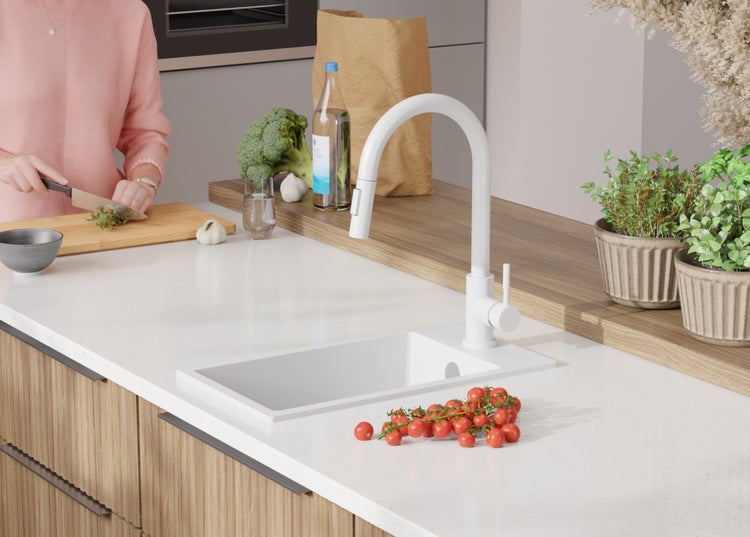 Küchenszene mit Spüle, Armatur und Lebensmitteln auf der Arbeitsplatte.