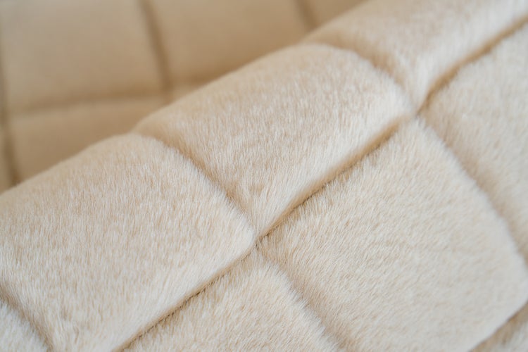 Nahaufnahme eines gesteppten Kunstfellgewebes mit weicher Textur und quadratischem Muster.