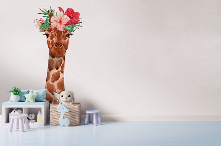 Wandtattoo Giraffe mit Blumenkranz in hellem Kinderzimmer mit Regal, Spielzeug und Hockern.