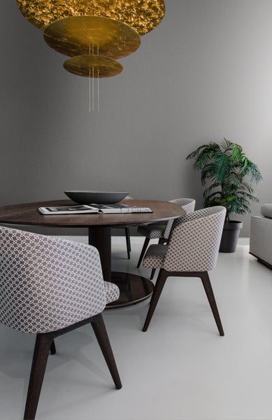 Esszimmer mit Esstisch, Stühlen und Zimmerpflanze unter einer Hängeleuchte