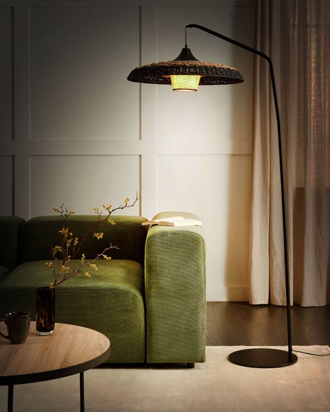 Wohnzimmer mit Stehlampe, Sofa, Couchtisch und Dekoration für eine gemütliche Atmosphäre