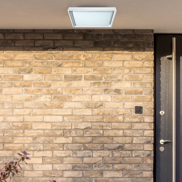 Rechteckige Deckenleuchte an einer Backsteinmauer neben einer Tür