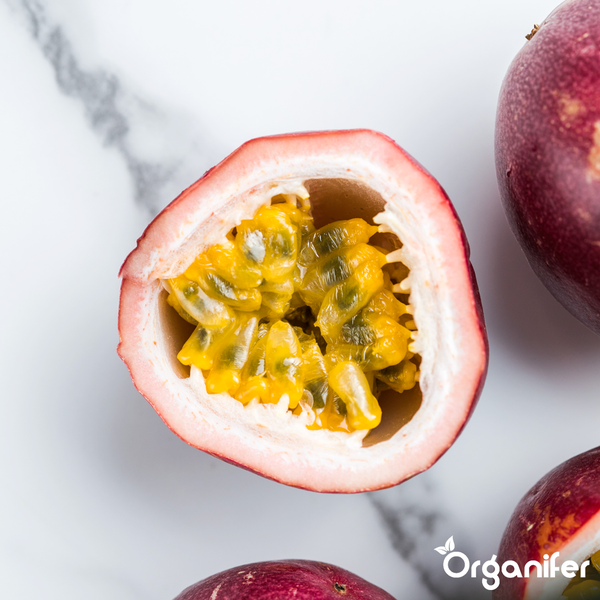 Halbierte Passionsfrucht mit Fruchtfleisch und Kernen. Organifer Logo.