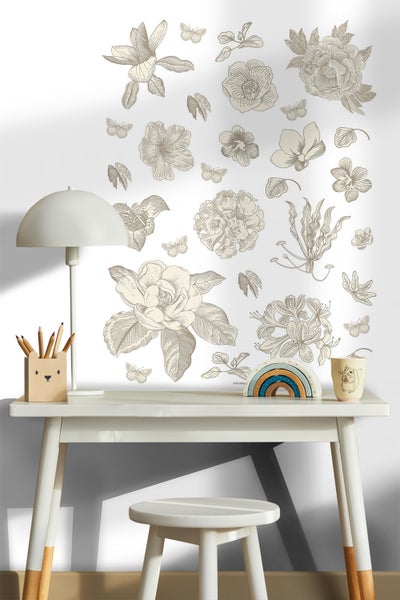 Schreibtisch mit Stuhl, Lampe, Stifthalter, Regenbogen und Tasse vor einer Wand mit Blumen- und Schmetterlingsmotiven