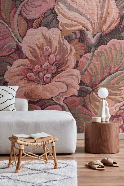 Gemütliches Wohnzimmer mit floraler Wandtapete, Sitzhocker, Sofa und Tischleuchte