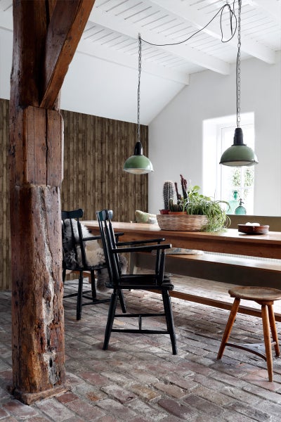 Rustikaler Essbereich mit Holztisch, Stühlen, Stehleuchten und Holzsäule