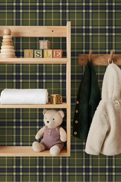 Vliestapete mit grünem Karomuster in einem organisierten Kinderzimmer mit Holzregal, Spielzeug und Kinderkleidung.