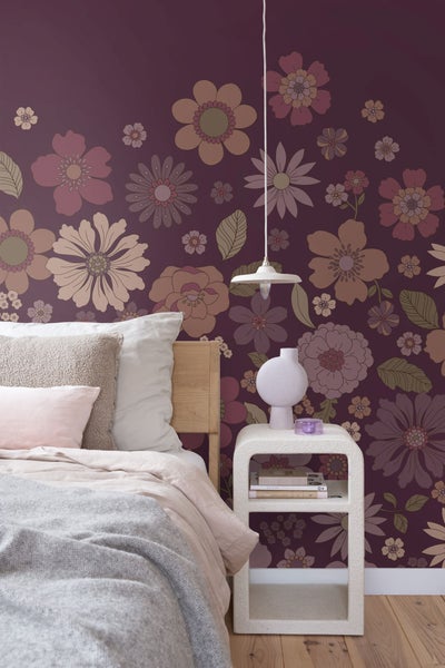 Schlafzimmer mit Bett, Nachttisch, Pendelleuchte und floraler Tapete