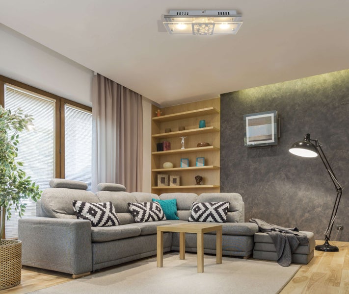 Wohnzimmer mit Sofa, Couchtisch, Regalen und Deckenleuchte