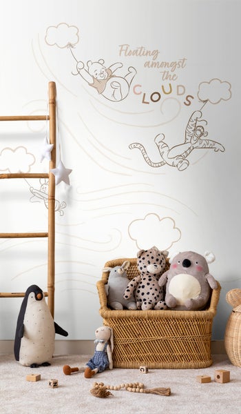 Dekoratives Kinderzimmer mit Wandtattoo, Leiter und Stofftieren in einem geflochtenen Korb
